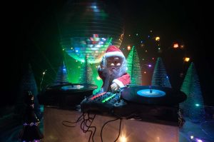 SANTA CHRISTMAS DJ – DJ Sime Disco Hire Dj mixer with headphones on dark nightclub background with Christmas tree DJ Sime Christmas Events DJ